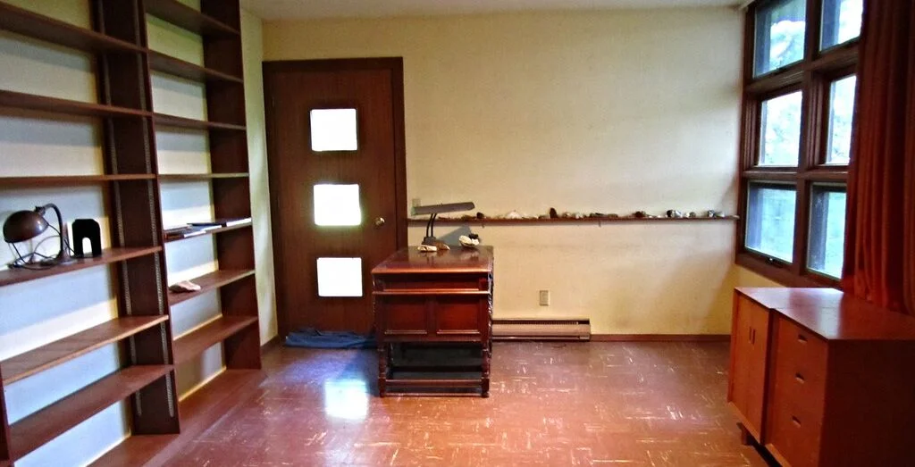 Walter's mostly empty office with a desk and Frank Lloyd Wright designed furniture